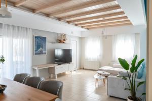 a living room with a television and a table at Villa Eos Mastichari - with heated pool in Mastichari
