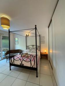 聖吉爾萊班的住宿－Prana Lodge Saint Gilles les Bains 800 m de la plage，一间卧室配有一张带金属框架的床