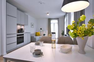 a kitchen and living room with a table with a vase of flowers at Lüttjeod Apartmentvilla Lüttjeod Apartmentvilla 09 in Langeoog