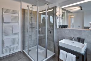 a bathroom with a glass shower and a sink at Lüttjeod Apartmentvilla Lüttjeod Apartmentvilla 16 in Langeoog +17 photos