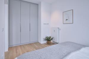 a bedroom with white walls and a bed at Lüttjeod Apartmentvilla Lüttjeod Apartmentvilla 18 in Langeoog