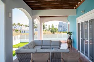 a living room with a couch and chairs on a porch at Villa Eos Mastichari - with heated pool in Mastichari