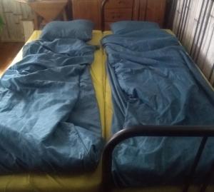 a bed with blue sheets on top of it at Sjöstugan Bodarna Hedemora in Hedemora