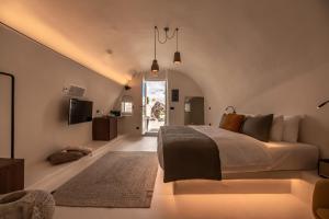 a bedroom with a large bed and a tv at Twenty One Suites in Oia