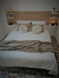 Una cama con almohadas y una manta. en Apartamento Merlot 11, en Novelda