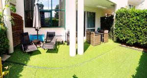 ディジョンにあるRomantisme et glamour avec spa, piscine et jardinの家の床に緑の芝生があるパティオ