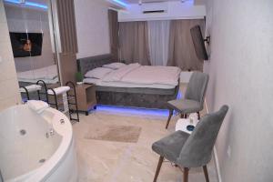 La salle de bains est pourvue d'un lit et d'une baignoire. dans l'établissement Apartman De Lux - Cacak, à Čačak