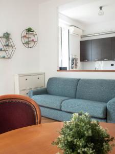 a living room with a blue couch and a table at Soffio Di Mare in Camogli