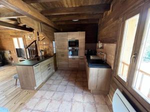 a large kitchen with wooden walls and wooden floors at Chalet 6A dans les Pyrénées proche d'Andorre in LʼHospitalet-près-lʼAndorre