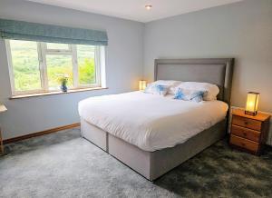 um quarto com uma cama grande e uma janela em Lark Rise Holiday Home Glenbeigh em Glenbeigh