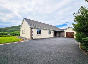 a large white house with a driveway at Lark Rise Holiday Home Glenbeigh in Glenbeigh