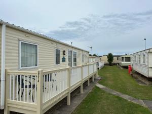 una fila de casas móviles estacionadas en un patio en Golden Palm Resort, Sherwood Plot, Abi Windsor S214, 6 Berth en Chapel Saint Leonards