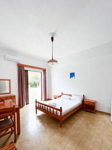 1 dormitorio con cama y ventana grande en Stamiris Beach Hotel, en Vasilikos