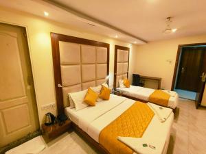 ein Hotelzimmer mit 2 Betten und einer Tür in der Unterkunft Apex Hotel in Mumbai