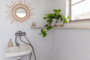 a bathroom with a sink and a mirror at Platia Tinos Cycladic Cottage in Platiá