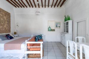una camera con letto, tavolo e sedie di Platia Tinos Cycladic Cottage a Platiá