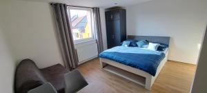 a bedroom with a bed and a couch and a window at Pension ANDREA in Mikulov