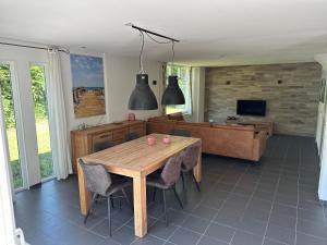 a living room with a wooden table and a couch at Vakantiehuisje drenthe gasselterveld in Gasselte