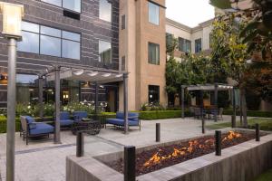 um pátio em frente a um edifício com cadeiras e mesas em Staybridge Suites Carlsbad/San Diego, an IHG Hotel em Carlsbad