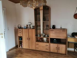 Cette chambre comprend un meuble en bois et un lustre. dans l'établissement Ferienwohnung Gotha, à Gotha