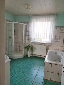 La salle de bains est pourvue d'une baignoire, d'une douche et d'un lavabo. dans l'établissement Ferienwohnung Gotha, à Gotha