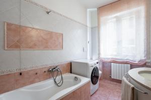 a bathroom with a tub and a toilet and a sink at Sesto di Moriano-Cozy Apt with Garden&Parking! in Lucca