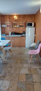 a kitchen with tables and chairs and a refrigerator at Willa Aura in Mielno