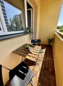 d'un balcon avec une table, des chaises et une fenêtre. dans l'établissement Pärnu Sunshine Majutus, à Pärnu