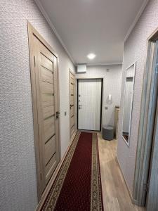 un couloir avec deux portes et un tapis rouge dans l'établissement Pärnu Sunshine Majutus, à Pärnu