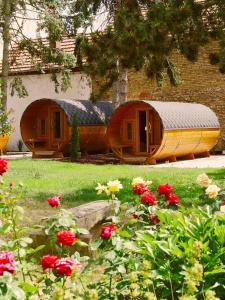 two wooden boats sitting in a yard with flowers at Urige Schlaffässer im Winzergarten inklusive Weinprobe in Bockenheim