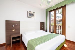 Un dormitorio con una cama grande y una ventana en Hotel Villa Cipro, en Lido de Venecia