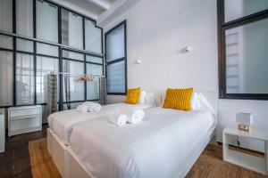a large white bed in a room with large windows at Poble Nou I You Stylish Apartments in Barcelona
