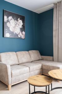 a living room with a couch and two tables at RentPlanet - Apartament Piłsudskiego in Wrocław