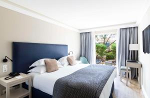 een slaapkamer met een groot bed en een raam bij Best Western Premier Santa Maria in LʼÎle-Rousse