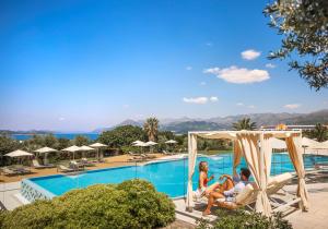 um grupo de pessoas sentadas em cadeiras ao lado de uma piscina em Valamar Lacroma Dubrovnik Hotel em Dubrovnik