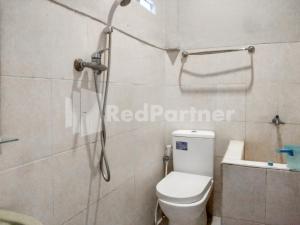 a bathroom with a shower and a toilet in it at The SO Hotel Mitra RedDoorz in Pangandaran