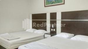 Postel nebo postele na pokoji v ubytování The SO Hotel Mitra RedDoorz