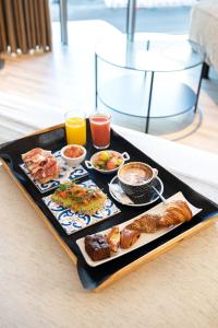 ア・コルーニャにあるホテル プラザのテーブルの上に朝食用の食品とドリンクを用意したトレイ