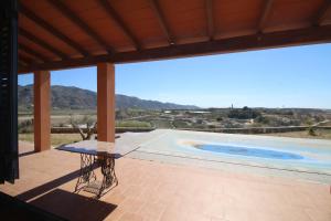 a patio with a table and a swimming pool at RA694 Casa con piscina de 4 dormitorios in Cuevas del Almanzora