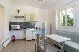 Una pequeña cocina con una mesa y un refrigerador. en Green Retreats 1 Paros, en Isterni