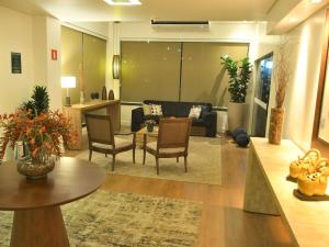 a living room with a couch and a table and chairs at Hotel Araraquara By Mercure in Araraquara