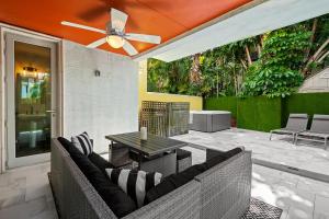 patio con sofá, mesa y ventilador de techo en Casa Central: In the Heart of Fort Lauderdale!, en Fort Lauderdale