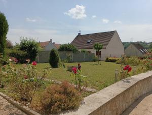 einen Garten mit Blumen und einer Haltewand in der Unterkunft La rose de Provins in Provins