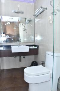 a bathroom with a white toilet and a sink at PARK PRIDE INN in Patna