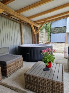 a patio with a hot tub and a table and flowers at Casa Haiducului in Baia Mare