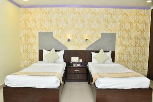 a bedroom with two beds and a wall at PARK PRIDE INN in Patna
