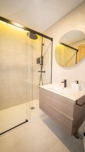 a bathroom with a sink and a shower with a mirror at center cathedral suite in Granada