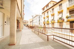 an empty street in a city with buildings at center cathedral suite in Granada