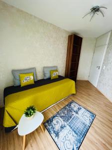 Apartment Künzelsau في كونتسلزاو: غرفة نوم بسرير اصفر وطاولة