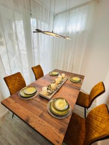 Apartment Künzelsau في كونتسلزاو: طاولة خشبية عليها لوحات وطعام